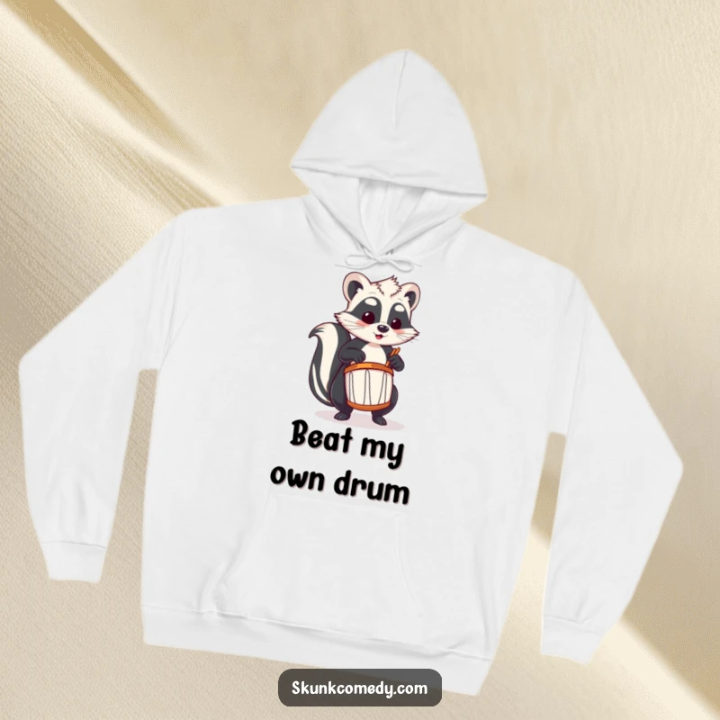 Funny skunk hoodie showing a skunk passionately playing a tiny drum, perfect for music lovers.