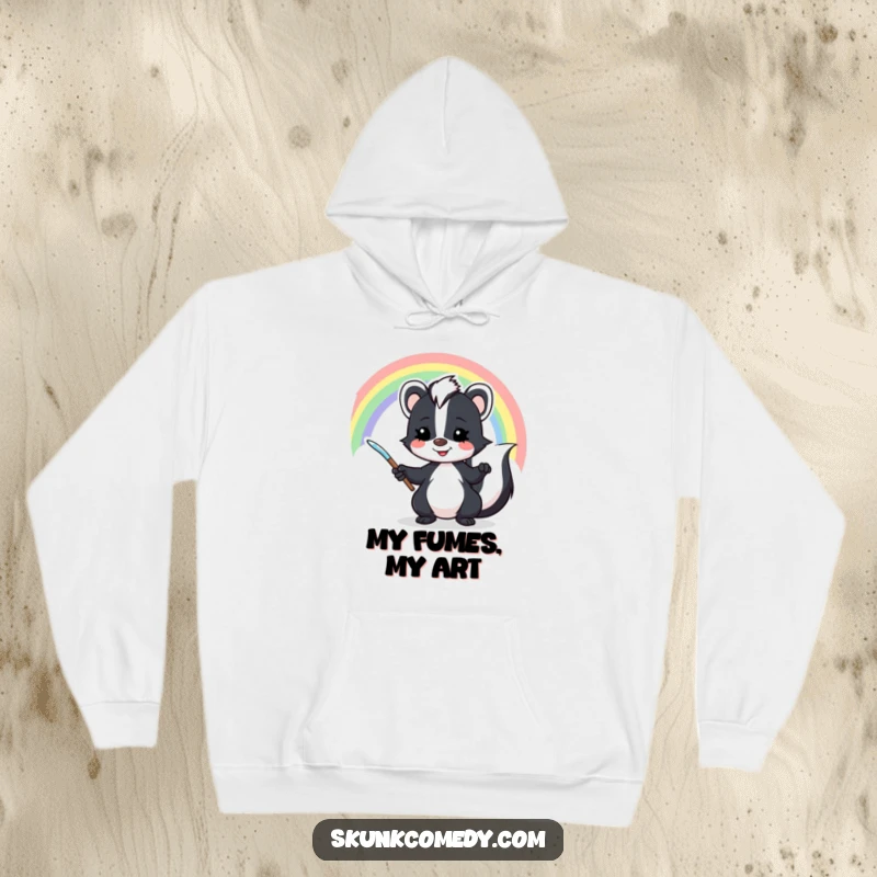 Funny skunk hoodie apparel showing a mischievous skunk artistically painting a beautiful rainbow against a sky backdrop.